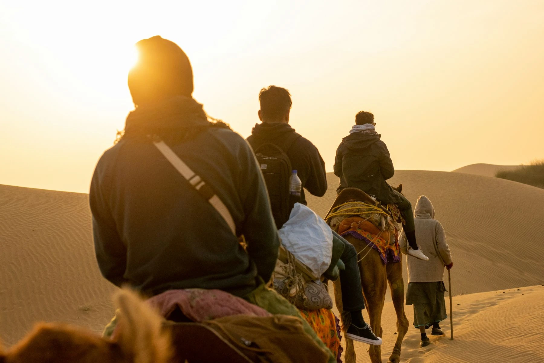 People riding camels on the dunes at Jaisalmer, Rajasthan